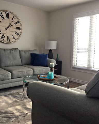 Living room with grey sofas and large wall clock at Hammer Haus II