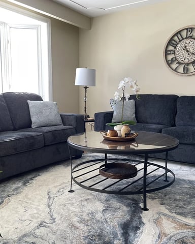 Living room with dark sofas and marble-patterned rug at Hammer Haus III