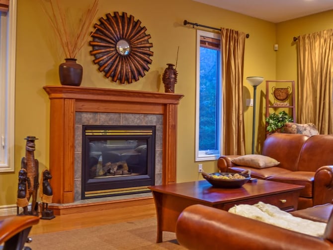 Living room with gas fireplace, leather sofas, and warm yellow walls at Hammer Haus