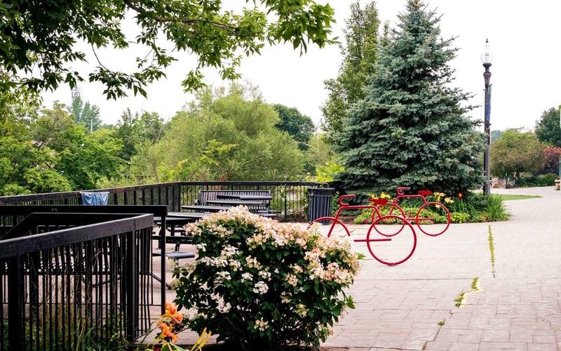 Riverside park with red bicycle sculpture, Fergus
