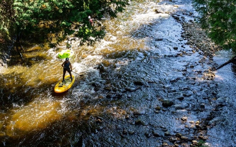 Paddleboarder navigating rapids