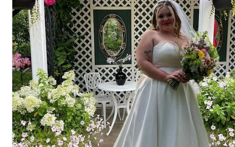Bride on the lattice porch with hanging flowers