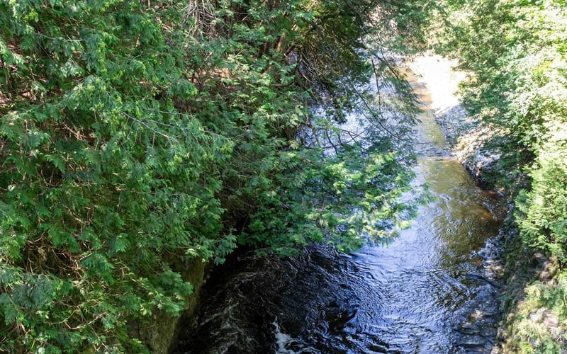 Solo rafter shooting rapids through tall rock walls