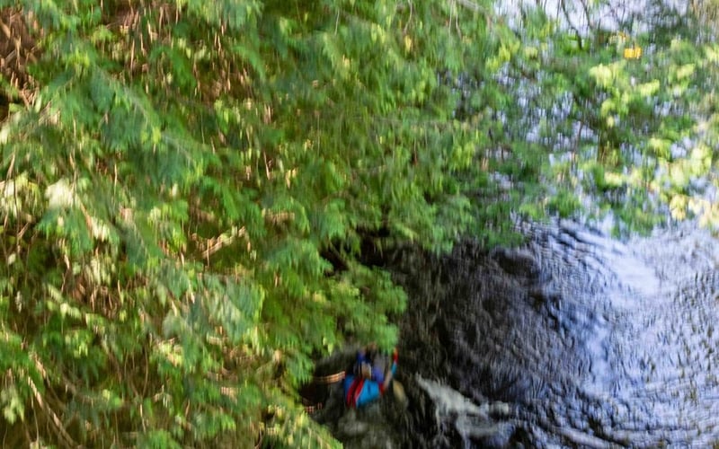 Aerial of tubers going over a small waterfall