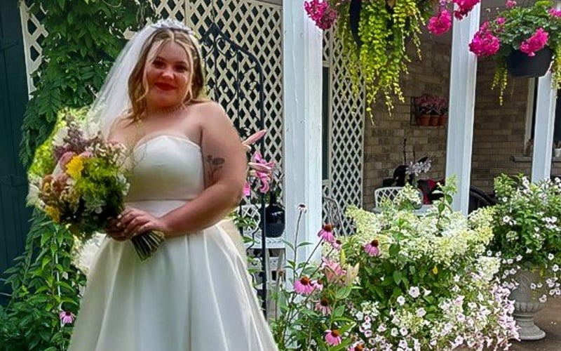 Bride pointing among the flower baskets