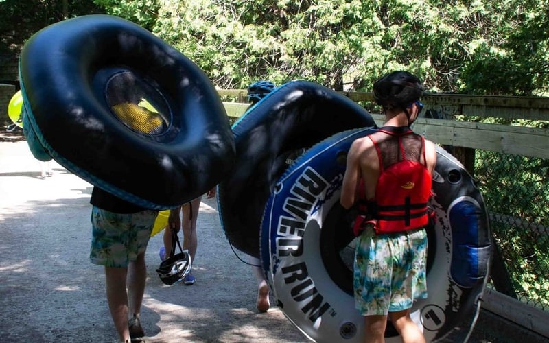 People carrying tubes on a bridge